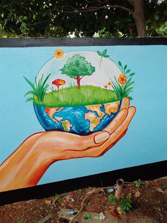 Colourful wall painting showing a hand holding earth and greenery